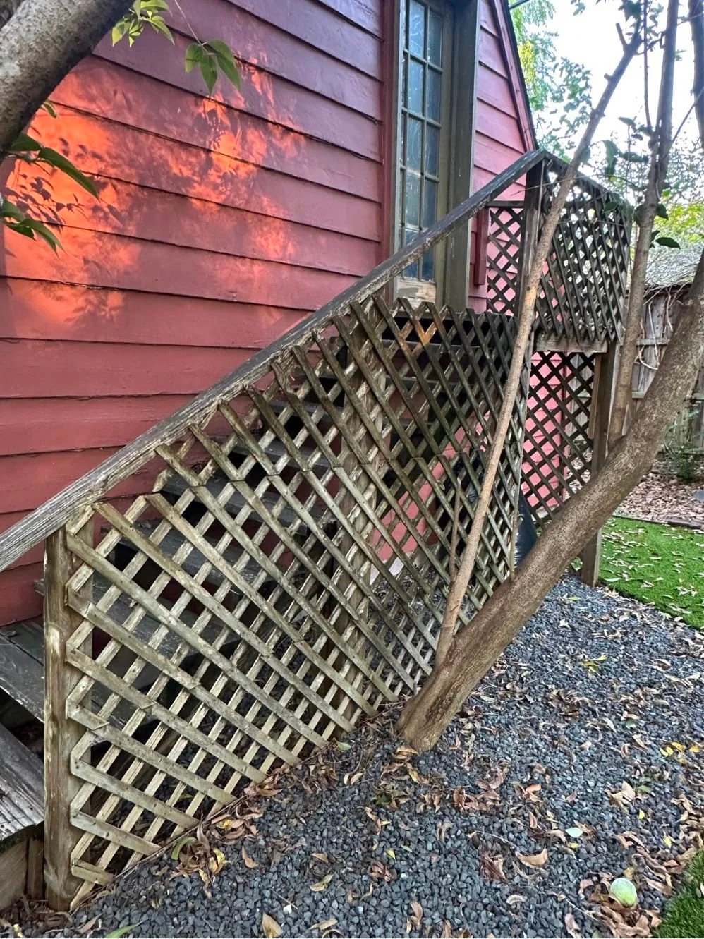 Weathered lattice on barn stairs before repair