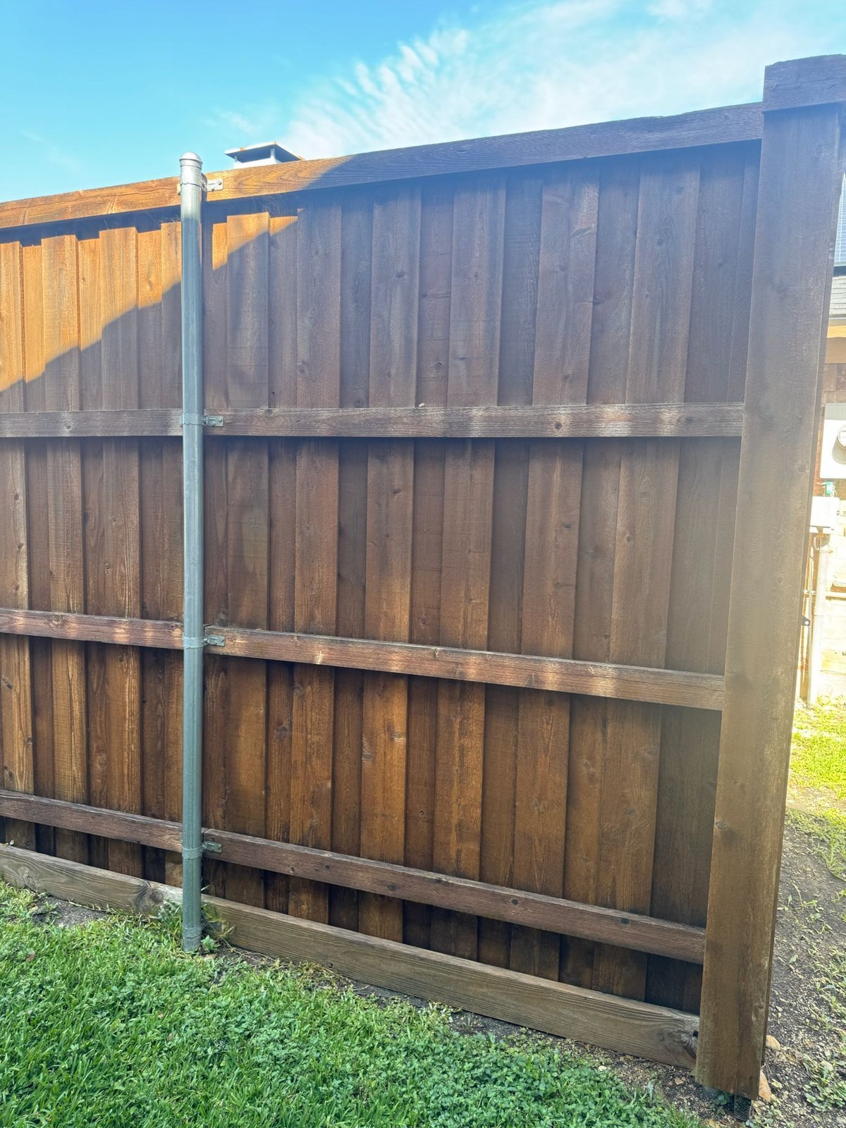 Wood fence staining and restoration in Dallas backyard
